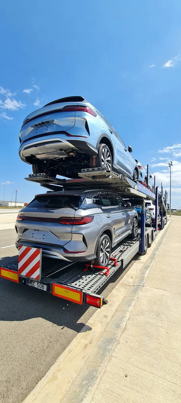 Du prabangūs automobiliai ant priekabos